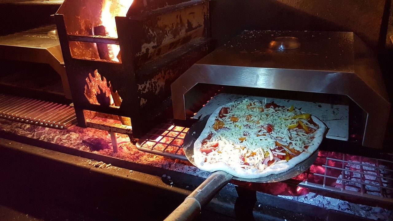 Home Fires pizza oven in actie op de braai