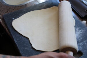 Rol het pizza deeg vervolgens uit