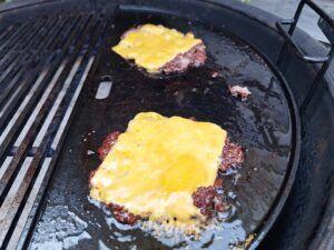 Doe de cheddar kaas op het vlees en laat smelten.
