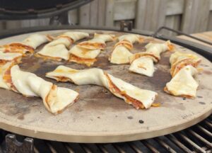 kaasstengels op pizzasteen in BBQ